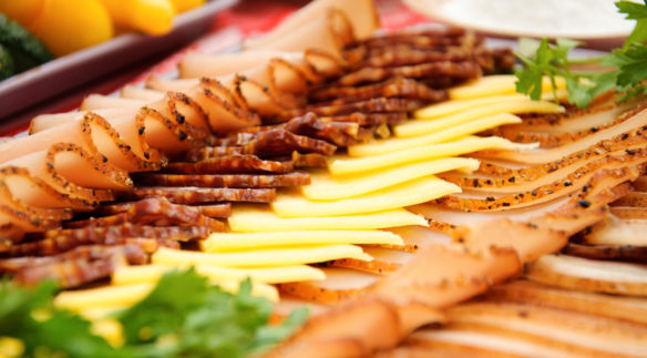 An array of different meats and cheeses consisting of ham, turkey, bacon and american cheese