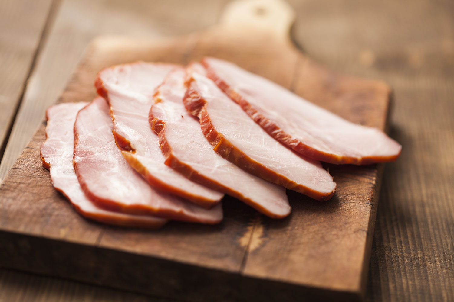 Cutting board with six slices of ham